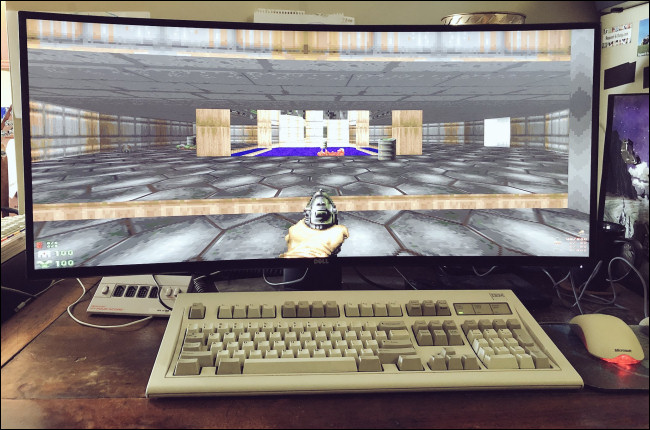 "Doom" on a widescreen monitor behind a desktop keyboard and mouse.