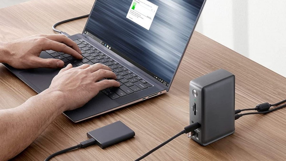 Person using laptop connected to laptop docking station